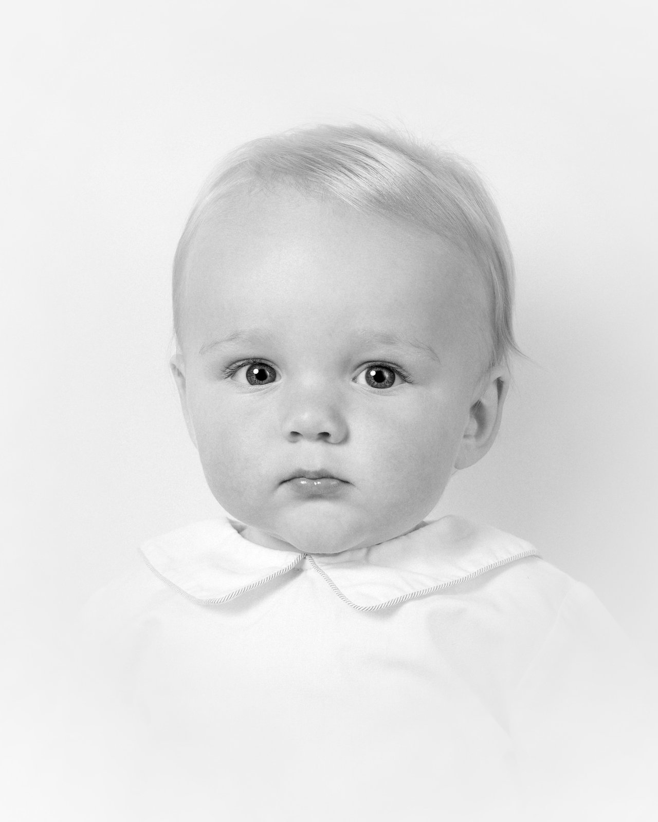 Heirloom portrait — a young child in a white peter-pan collar, softly lit
